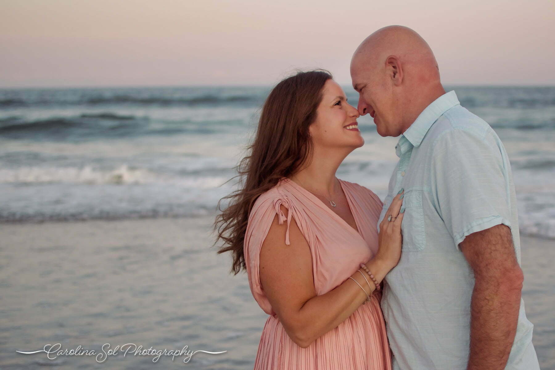 Couple photography session embracing on Wrightsville Beach, NC.