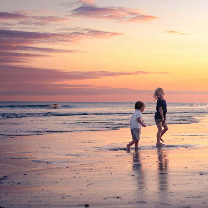Family photography Holden Beach NC candid colorful sunset.
