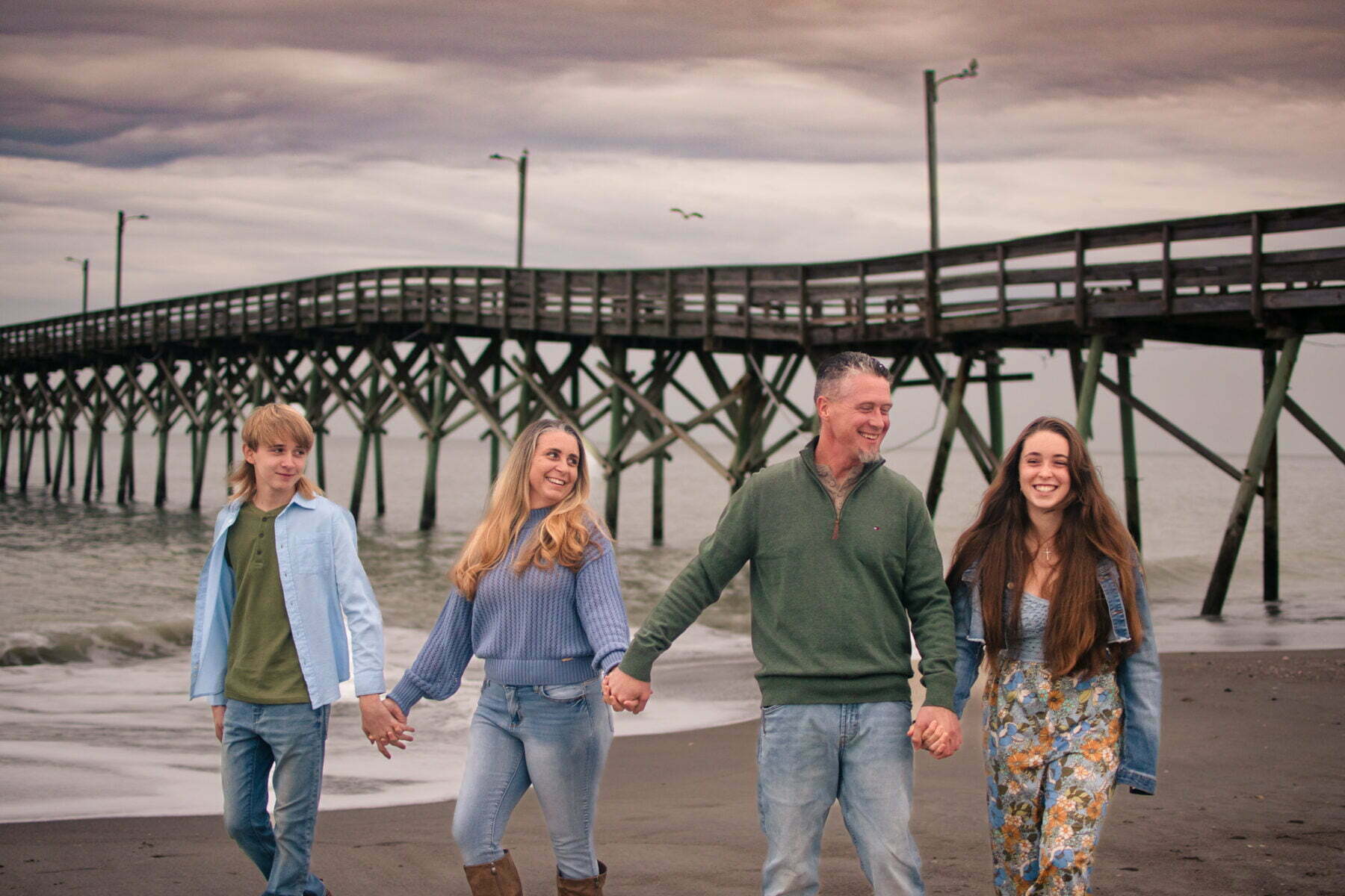Candid family portrait photography session at Holden Beach Pier, NC.