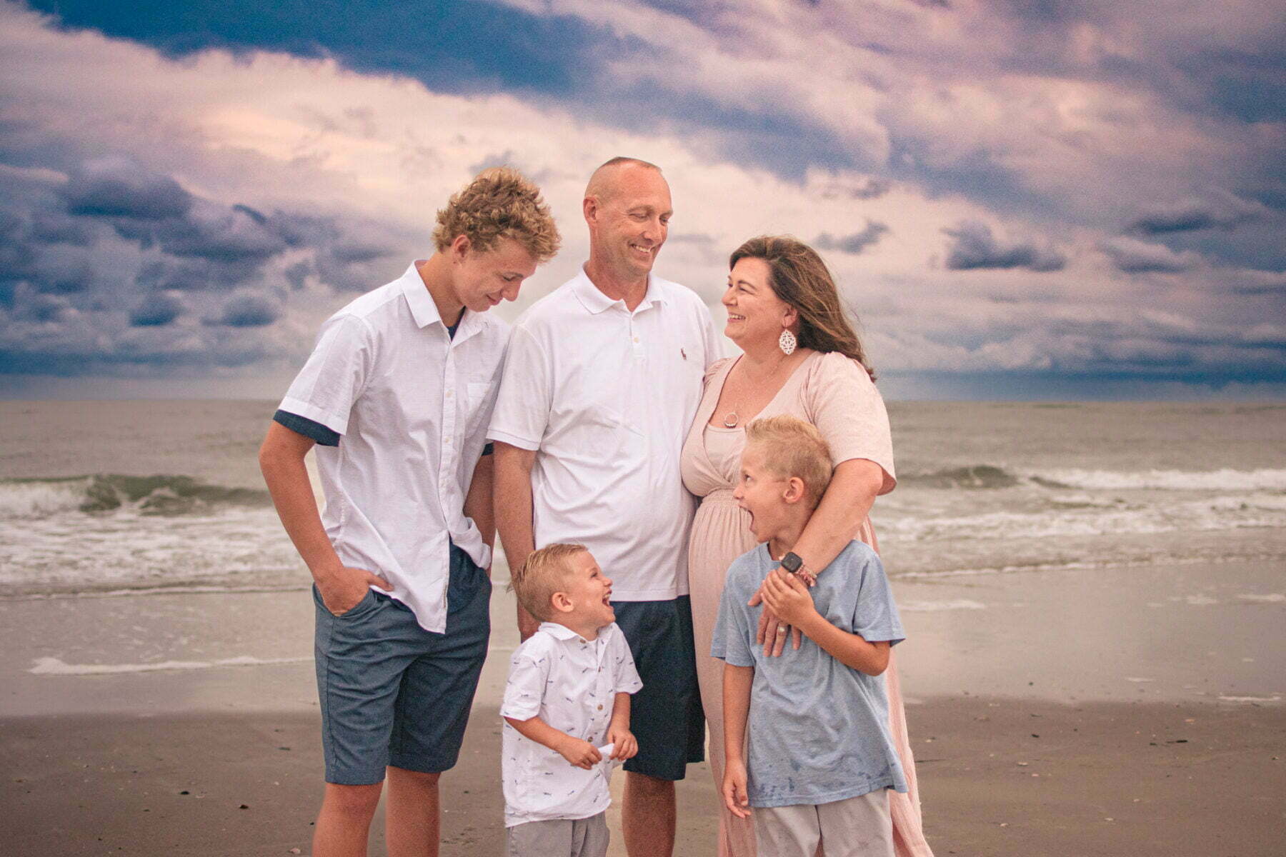 Family laughing together during lifestyle photography session Holden Beach, NC.