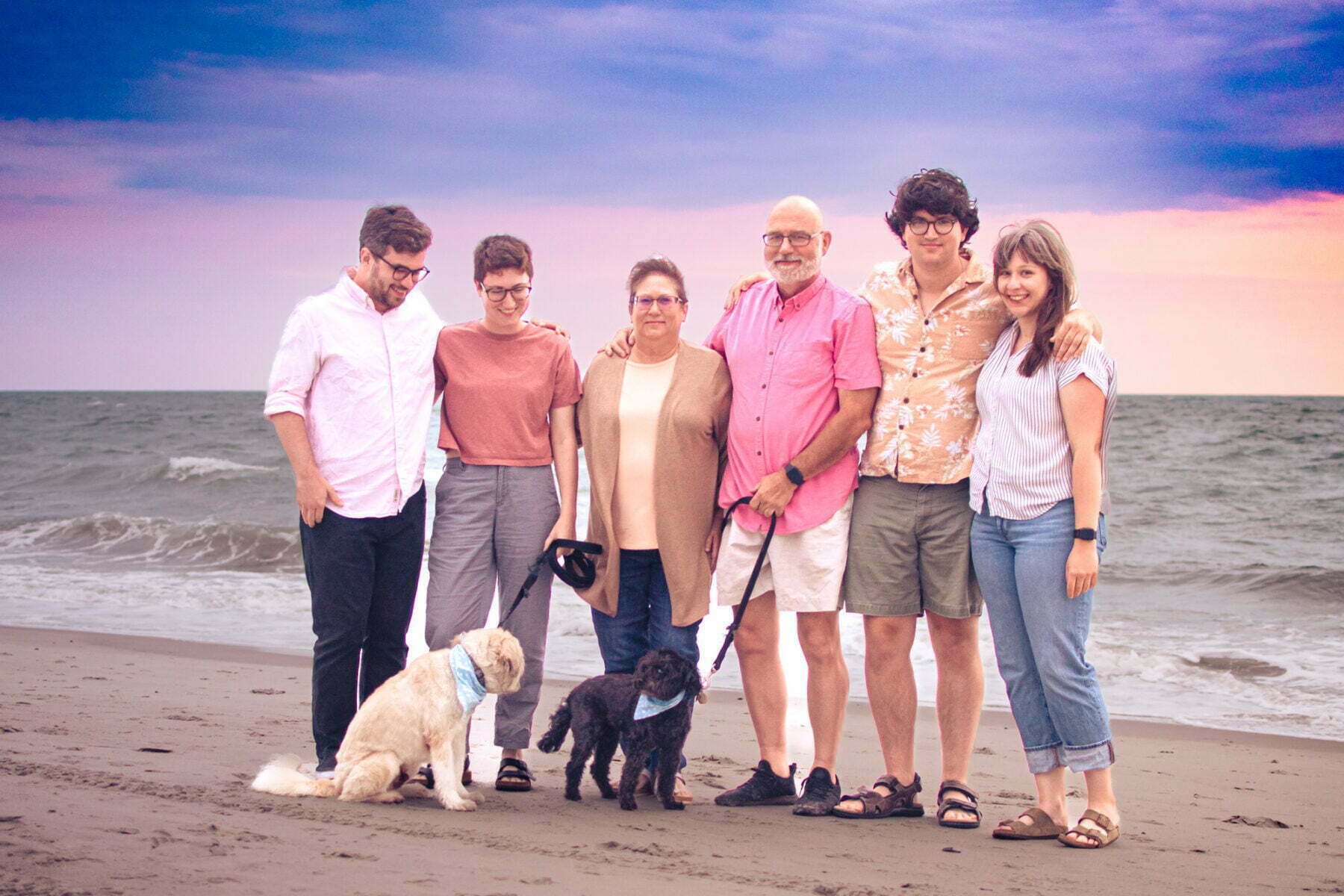 Oak Island, NC family photography session with dogs on the beach at sunset.