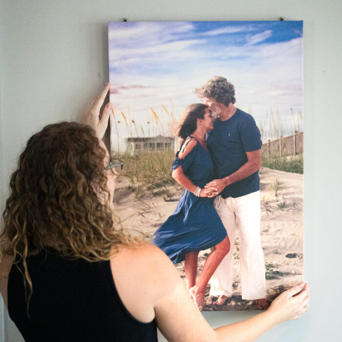 Installing custom wall art canvas collection beach house Holden Beach, NC.